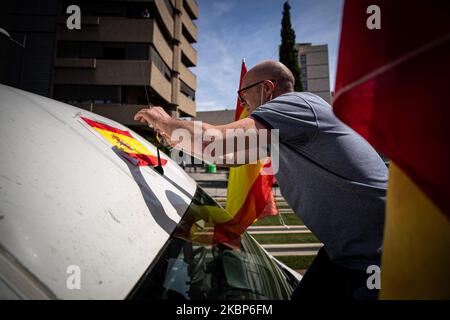 Ein Mann setzt eine spanische Flagge in seinen Van, bevor der Protest gegen die Regierung des spanischen Premierministers Pedro Sanchez und die Bewältigung der Coronavirus-Krise in Granada am 23. Mai 2020 auf einer Autolandemonstration stattfand. Die rechtsextreme Partei fordert das Ende der Haft und den Ausnahmezustand, weil sie der Ansicht sind, dass dies ihre Rechte und alle Spanier einschränkt. (Foto von Fermin Rodriguez/NurPhoto) Stockfoto