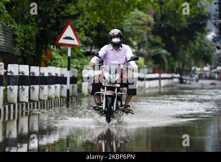 Pendler waten am Samstag, den 23. Mai 2020, nach starken Regenfällen in Guwahati, Assam, Indien, durch eine wasserdurchwoge Straße. (Foto von David Talukdar/NurPhoto) Stockfoto