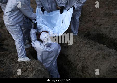 Arbeiter tragen am Mai die Leiche eines COVID-19-Patienten zur Beerdigung auf einem Friedhof in Dhaka, Bangladesch, zu seinem Grab. 23,2020. (Foto von Syed Mahamudur Rahman/NurPhoto) Stockfoto