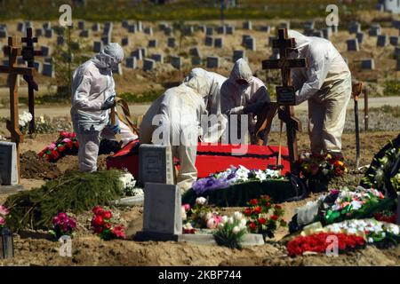 Friedhofsmitarbeiter in chemischen Schutzanzügen vergraben am 23. Mai 2020 in Kolpino, außerhalb von St. Petersburg, Russland, Opfer von COVID-16. (Foto von Sergey Nikolaev/NurPhoto) Stockfoto
