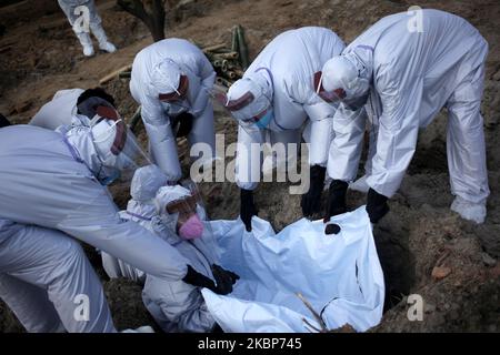 Arbeiter tragen am Mai die Leiche eines COVID-19-Patienten zur Beerdigung auf einem Friedhof in Dhaka, Bangladesch, zu seinem Grab. 23,2020. (Foto von Syed Mahamudur Rahman/NurPhoto) Stockfoto