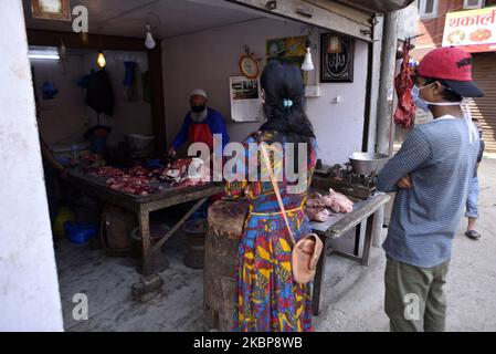 Nepalesische muslimische Menschen kaufen Fleisch, nachdem sie während der vollständigen Nation-Sperre ein rituelles Gebet auf Eid al-Fitr anboten, da sie Bedenken über die Ausbreitung des Corona-Virus (COVID-19) in Kathmandu, Nepal, am Montag, den 25. Mai 2020 hatten. Eid wird als Abschluss des einmonatigen Fastens von Sonnenaufgang bis Sonnenuntergang im Ramadan gefeiert. Die nepalesische Regierung kündigte einen öffentlichen Feiertag für die Eid al-Fitr-Fest an. (Foto von Narayan Maharjan/NurPhoto) Stockfoto