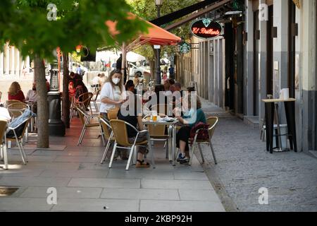 Am 25. Mai 2020 sitzen die Kunden an gesellschaftlich voneinander entfernten Tischen auf der Außenterrasse einer Bar, die in Madrid, Spanien, mit reduzierter Kapazität betrieben wird. Heute ist der erste Tag, an dem Madrid an die ''Fase 1'' übergeben wurde. Das bedeutet, dass es in der Stadt erlaubt ist, die Bars, Pubs und Restaurants zu öffnen. Sie können nur auf den Terrassen oder zum Mitnehmen dienen. (Foto von Jon Imanol Reino/NurPhoto) Stockfoto