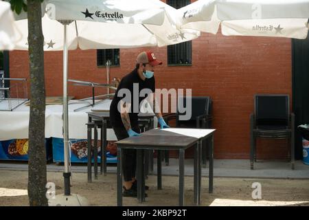 Ein Kellner desinfiziert am 25. Mai eine Tischfläche auf der Außenterrasse eines Cafés in Madrid, Spanien. Heute ist der erste Tag von Madrid in der Phase 1 der Enteskalation der Haft, können Menschen auf Terrassen und Terrassen gehen und beginnen, mit Gruppen von mehr als 10 Personen, Parque del Retiro, Madrid zu bleiben. (Foto von Jon Imanol Reino/NurPhoto) Stockfoto