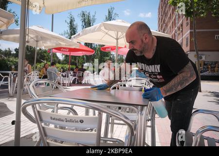 Ein Kellner desinfiziert am 25. Mai eine Tischfläche auf der Außenterrasse eines Cafés in Madrid, Spanien. Heute ist der erste Tag von Madrid in der Phase 1 der Enteskalation der Haft, können Menschen auf Terrassen und Terrassen gehen und beginnen, mit Gruppen von mehr als 10 Personen, Parque del Retiro, Madrid zu bleiben. (Foto von Antonio Navia/NurPhoto) Stockfoto