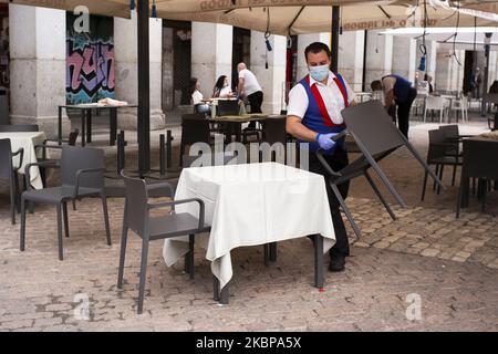 Ein Kellner, der eine schützende Gesichtsmask trägt, arbeitet in Restaurants, Cafés und Bars, die am 26. Mai 2020 nach 9 Wochen schwerer Sperre durch Covid-19 in Madrid, Spanien, auf der Plaza Mayor eröffnet werden dürfen. Die Regionen von Madrid und der Ballungsraum von Barcelona traten in die Phase 1 ein, die es den Straßencafés ermöglicht, mit einer Kapazität von 50 % wieder zu öffnen (Foto von Oscar Gonzalez/NurPhoto) Stockfoto