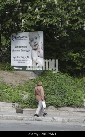 Eine Frau geht an der Werbung der BioTexCom-Klinik neben ihren HQs in Kiew, Ukraine, 18. Mai 2020 vorbei. 56 Babys, die zur Leihmutter von Müttern in der ukrainischen BioTexCom-Klinik für Eltern aus China, Spanien, Deutschland, Frankreich, Italien, Bulgarien und Rumänien warten auf ihre biologischen Eltern, die aufgrund von Grenzschließungen während der Coronavirus-Pandemie COVID-19 die Ukraine nicht erreichen können. (Foto von Sergii Chartschenko/NurPhoto) Stockfoto