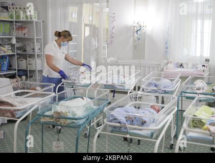 Babysitter kümmert sich um die Babys in einem Zimmer im Venice Hotel der BioTexCom Klinik in Kiew, Ukraine, 19. Mai 2020. 56 Babys, die zur Leihmutter von Müttern in der ukrainischen BioTexCom-Klinik für Eltern aus China, Spanien, Deutschland, Frankreich, Italien, Bulgarien und Rumänien warten auf ihre biologischen Eltern, die aufgrund von Grenzschließungen während der Coronavirus-Pandemie COVID-19 die Ukraine nicht erreichen können. (Foto von Sergii Chartschenko/NurPhoto) Stockfoto