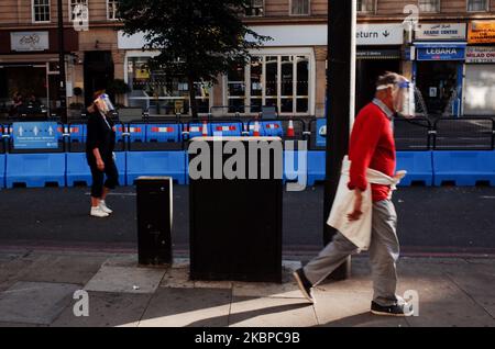 Ein älteres Paar mit Gesichtsschutz geht am 28. Mai 2020 an einem Abschnitt des „Streetspace“-Programms des Londoner Bürgermeisters vorbei, das darauf ausgelegt ist, die Kapazität für Fußgänger und Radfahrer auf bestimmten Straßen zu erweitern, während die Richtlinien zur sozialen Distanzierung weiterhin in Kraft bleiben, auf der Edgware Road in London, England. Das Vereinigte Königreich befindet sich jetzt in der zehnten Woche der Blockierung des Coronavirus, und die Gesamtzahl der Todesfälle liegt laut der heutigen aktualisierten Zählung des Gesundheitsministeriums bei 37.837. Der britische Premierminister Boris Johnson steht unterdessen weiterhin unter unerbittlichen Druck, weil er sich weigert, seinen obersten Adjutanten, Dominic Cumm, zu entlassen Stockfoto