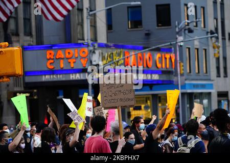 Demonstranten werden gesehen, wie sie an der Radio City Music Hall vorbeigehen, während sie sich am 31. Mai 2020 in New York City gegen den Tod des Minneapolis, Minnesota-Mannes George Floyd, in den Händen der Polizei versammelten. Floyds Tod wurde in einem Video festgehalten, das über den Vorfall viral wurde. (Foto von John Nacion/NurPhoto) Stockfoto