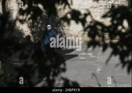 Eine Frau mit verdecktem Kopf und Gesichtsmaske auf Spaziergängen durch den Florivsky Nonnenkloster-Hof in Kiew, Ukraine, 1. Juni 2020. Das siebte von Russland unterstützte Kloster der Ukrainischen Orthodoxen Kirche wurde wegen eines Coronavirus-Ausbruchs in der Ukraine zur Quarantäne gesperrt. 26 aktive COVID-19-Fälle wurden im Kloster von Himmelfahrt (auch bekannt als Florivsky Kloster) in der Innenstadt von Kiew bestätigt. (Foto von Sergii Chartschenko/NurPhoto) Stockfoto