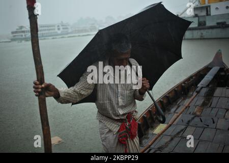 Ein Bootsmann wartet auf Passagiere bei starken Regenfällen im Fluss Buriganga in der Nähe des Sadarghat Startterminals in Dhaka, Bangladesch, am Donnerstag, den 04.06.2020. (Foto von Syed Mahamudur Rahman/NurPhoto) Stockfoto