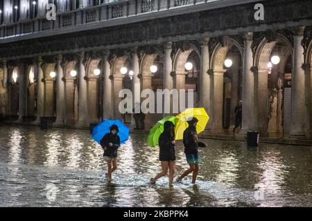Touristen, die durch den Markusplatz laufen, der vollständig vom Wasser bedeckt ist, als das Wasser bis 116cm auf den Meeresspiegel stieg. Das Phänomen des Hochwassers ist während des Sommers ungewöhnlich, da es in den letzten 20 Jahren nur 4 Mal passiert ist. Venedig wurde letzten November von einem der höchsten Hochwassergewässer der letzten Jahre und dann von der Coronavirus-Krise getroffen, da der größte Teil des Tourismus verschwunden ist, auch wenn Italien nun offiziell die Grenze wieder geöffnet hat und einige Besucher beginnen, nach Venedig zurückzukehren. Am 4. Juni 2020 in Venedig, Italien. (Foto von Giacomo Cosua/NurPhoto) Stockfoto