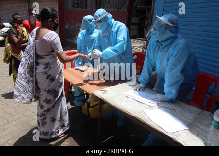 Am 07. Juni 2020 misst ein Mitarbeiter im Gesundheitswesen den Puls einer Frau im Slum Dharavi in Mumbai, Indien. Indien befindet sich weiterhin im landesweiten Sperrgebiet, um die Ausbreitung der Coronavirus-Pandemie (COVID-19) zu kontrollieren. (Foto von Himanshu Bhatt/NurPhoto) Stockfoto