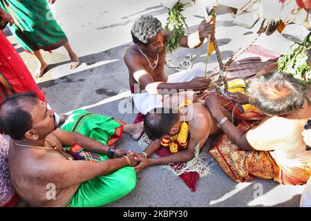 Haken werden in den Rücken und die Beine eines tamilischen Hindu-Anhängers gesetzt, der bereit ist, das para-Kavadi-Ritual des Vinayagar Ther Thiruvizha Festivals in Ontario, Kanada, durchzuführen. Die para-kavadi ist ein Akt der Buße und wird von eifrigen Anhängern unternommen, um die Krankheit eines geliebten Menschen zu beseitigen oder Gott um ein Kind zu bitten, in die Familie geboren zu werden. (Foto von Creative Touch Imaging Ltd./NurPhoto) Stockfoto