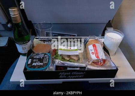 Bordmahlzeit mit Salat und Sandwich der Economy-Klasse, serviert mit Milch, Wasser, Ayran und einem Dessert. Flug mit Turkish Airlines während des COVID-19 Coronavirus-Pandemieausbruchs. In einem fast leeren Flugzeug sind weniger Passagiere zum Fliegen an Bord, während die Kabinencrew und die Flugbegleiter Schutzmasken tragen. Der Internationale Flug TK 1843 vom neuen Flughafen Istanbul in der Türkei in die Hauptstadt Athen in Griechenland wird von einem neuen, modernen und fortschrittlichen Flugzeug, einem Airbus A321neo mit Registrierung TC-LSN, betrieben. (Foto von Nicolas Economou/NurPhoto) Stockfoto