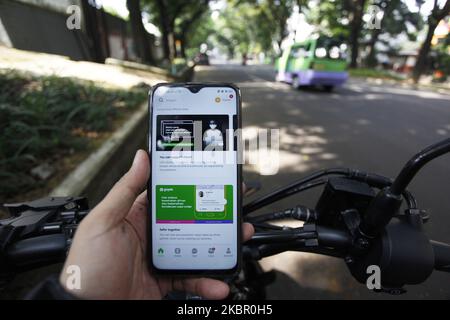 Ein Mann benutzt sein Mobiltelefon und benutzt die Gojek-App auf einer Straße in Bogor, Indonesien. 9. Juni 2020. Die Messaging-Plattform WhatsApp von Facebook Inc und PayPal Holdings Inc haben in den Anbieter von Zahlungen, Lebensmittelzustellung und Ride-Hailing-Apps Gojek investiert. Laut einer behördlichen Einreichung hält Facebook jetzt 2,4 Prozent der Anteile an Gojeks Fintech-Arm GoPay, während PayPal 0,6 Prozent der Anteile an GoPay hält (Foto Illustration by Adriana Adie/NurPhoto) Stockfoto