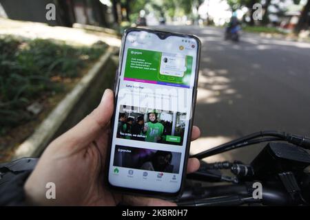 Ein Mann benutzt sein Mobiltelefon und benutzt die Gojek-App auf einer Straße in Bogor, Indonesien. 9. Juni 2020. Die Messaging-Plattform WhatsApp von Facebook Inc und PayPal Holdings Inc haben in den Anbieter von Zahlungen, Lebensmittelzustellung und Ride-Hailing-Apps Gojek investiert. Laut einer behördlichen Einreichung hält Facebook jetzt 2,4 Prozent der Anteile an Gojeks Fintech-Arm GoPay, während PayPal 0,6 Prozent der Anteile an GoPay hält (Foto Illustration by Adriana Adie/NurPhoto) Stockfoto