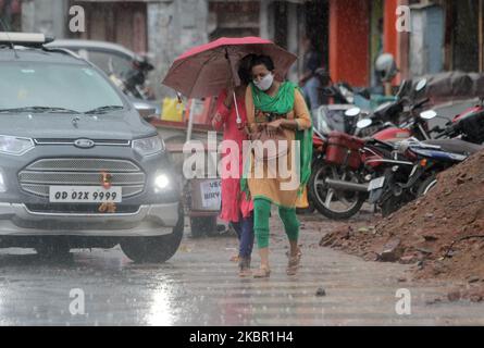 Am 10. Juni 2020 werden Menschen in der Regenzeit des Gewitters in der Hauptstadt Bhubaneswar des ostindischen Staates Odisha auf der Straße gesehen. Das indische MET-Ministerium warnt vor einem starken Regenfall in den östlichen Teilen des Landes, da sich der Monsun Indien nähert. (Foto von STR/NurPhoto) Stockfoto