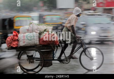 Am 10. Juni 2020 werden Menschen in der Regenzeit des Gewitters in der Hauptstadt Bhubaneswar des ostindischen Staates Odisha auf der Straße gesehen. Das indische MET-Ministerium warnt vor einem starken Regenfall in den östlichen Teilen des Landes, da sich der Monsun Indien nähert. (Foto von STR/NurPhoto) Stockfoto