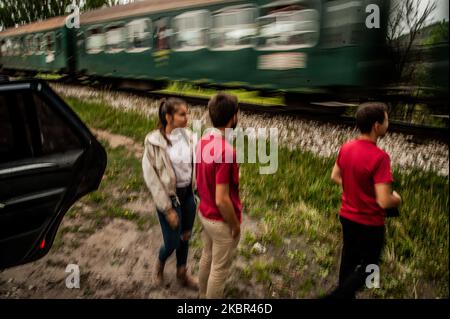 Kristian Vaklinov und seine Freunde von der Bürgervereinigung für Schmalspurbahn sind beim Fotografieren der Zugzusammensetzung der Schmalspurbahn in der Nähe der Stadt Velingrad, Bulgarien, zu sehen. Die Rhodopen-Schmalspurbahn in Bulgarien ist eine der wenigen bestehenden Schmalspurbahnen mit regelmäßigem Fahrplan in der Welt. Nicht nur als Attraktion genutzt. Es gilt als eine der besten Zugfahrten in Europa. Die Linie erhält ihren fertigen Look, wie sie heute von der Stadt Septemvri bis zur Stadt Dobrinishte im Jahr 1945 ist. 76 cm Spurweite, 3 Berge, viele Flüsse, mehrere gor Stockfoto