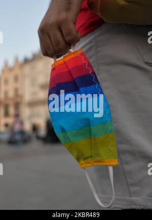 Ein LGBT-Aktivist, der mit einer Schutzmaske auf dem Krakauer Hauptmarkt gesehen wird. Ein Dutzend junger Aktivisten reagierte mit ihrer Anwesenheit auf eine inoffizielle Facebook-Veranstaltung namens „Regenbogendisko auf dem Hauptplatz“. Nach etwa 15min der Veranstaltung machten Aktivisten ein Gruppenbild am Mickiewicz-Denkmal. Ein paar Minuten später kamen zwei Spuren mit Mitgliedern der örtlichen Polizei und begannen, die Ausweise der Aktivisten zu überprüfen und so der Veranstaltung ein Ende zu setzen. Am Montag, den 12. Freitag, 2020, in Krakau, Polen. (Foto von Artur Widak/NurPhoto) Stockfoto