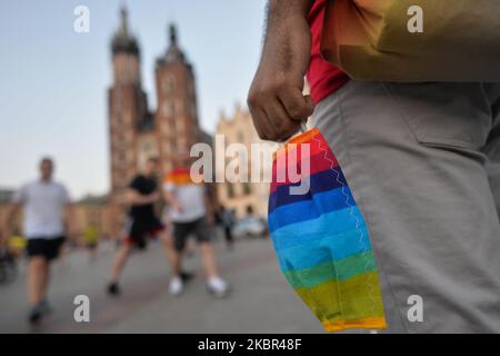 Ein LGBT-Aktivist, der mit einer Schutzmaske auf dem Krakauer Hauptmarkt gesehen wird. Ein Dutzend junger Aktivisten reagierte mit ihrer Anwesenheit auf eine inoffizielle Facebook-Veranstaltung namens „Regenbogendisko auf dem Hauptplatz“. Nach etwa 15min der Veranstaltung machten Aktivisten ein Gruppenbild am Mickiewicz-Denkmal. Ein paar Minuten später kamen zwei Spuren mit Mitgliedern der örtlichen Polizei und begannen, die Ausweise der Aktivisten zu überprüfen und so der Veranstaltung ein Ende zu setzen. Am Montag, den 12. Freitag, 2020, in Krakau, Polen. (Foto von Artur Widak/NurPhoto) Stockfoto