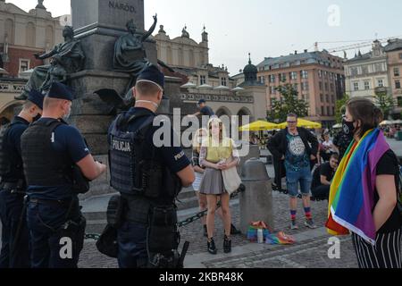 Eine Gruppe junger LGBT-Aktivisten, die während der Polizei-ID-Überprüfung neben dem Adam-Mickiewicz-Denkmal auf dem Krakauer Hauptmarkt gesehen wurden. Ein Dutzend junger Aktivisten reagierte mit ihrer Anwesenheit auf eine inoffizielle Facebook-Veranstaltung namens „Regenbogendisko auf dem Hauptplatz“. Nach etwa 15min der Veranstaltung machten Aktivisten ein Gruppenbild am Mickiewicz-Denkmal. Ein paar Minuten später kamen zwei Spuren mit Mitgliedern der örtlichen Polizei und begannen, die Ausweise der Aktivisten zu überprüfen und so der Veranstaltung ein Ende zu setzen. Am Montag, den 12. Freitag, 2020, in Krakau, Polen. (Foto von Artur Widak/NurPhoto) Stockfoto