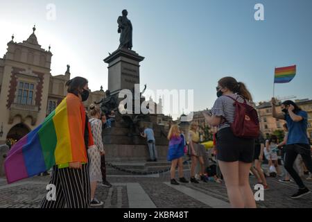 Eine Gruppe junger Menschen mit LGBT-Fahnen sah neben dem Adam-Mickiewicz-Denkmal auf dem Krakauer Hauptmarkt tanzen. Ein Dutzend junger Aktivisten reagierte mit ihrer Anwesenheit auf eine inoffizielle Facebook-Veranstaltung namens „Regenbogendisko auf dem Hauptplatz“. Nach etwa 15min der Veranstaltung machten Aktivisten ein Gruppenbild am Mickiewicz-Denkmal. Ein paar Minuten später kamen zwei Spuren mit Mitgliedern der örtlichen Polizei und begannen, die Ausweise der Aktivisten zu überprüfen und so der Veranstaltung ein Ende zu setzen. Am Montag, den 12. Freitag, 2020, in Krakau, Polen. (Foto von Artur Widak/NurPhoto) Stockfoto