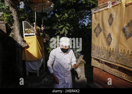 Der balinesische Hindu trägt eine Gesichtsmaske, während sie an der Zeremonie von Penebusan Gering Lara Malaradan während der Ausbreitung des Coronavirus (COVID-19) am 13. Juni 2020 im Dalem Kahyangan Tempel in Denpasar, Bali, Indonesien, teilnehmen. Die Zeremonie findet in allen Dörfern Balis statt. Es wird angenommen, dass das Ritual die Covid-19-Pandemie überwinden kann, die Bali und Indonesien seit Anfang dieses Jahres heimgesucht hat. (Foto von Johanes Christo/NurPhoto) Stockfoto