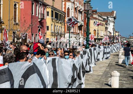 Menschen mit einem Schild, die darum bitten, den Massentourismus in Venedig zu stoppen. Mindestens 1500 Menschen haben am 13. Juni 2020 in Venedig, Italien, demonstriert und eine Verordnung gegen den Massentourismus in Venedig gefordert. Nach dem Coronavirus-Notfall brach die Tourismusindustrie in Venedig zusammen, aber viele Einheimische fordern neue Regeln für die Zukunft. An der Demonstration nahmen auch Menschen gegen große Schiffe Teil, die nach Venedig kamen. (Foto von Giacomo Cosua/NurPhoto) Stockfoto