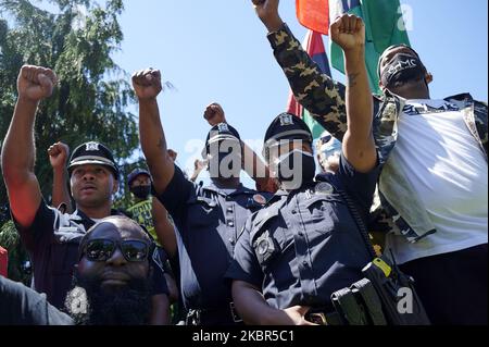 Schwarze Polizisten mit dem Polizeidezernat des Bezirks Camden schließen sich einem Gemeindeaktivisten bei einer Kundgebung an, die von Black Men Rising am 13. Juni 2020 im Farnham Park in Camden, NJ, vor der Statue von Christoper Columbus stand, veranstaltet wurde. (Foto von Bastiaan Slabbers/NurPhoto) Stockfoto