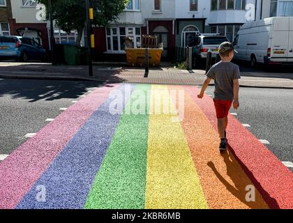 Der Sohn von Fotografen überquert die Straße, als der Londoner Stadtteil Greenwich Pride in London ihre Unterstützung zeigt, indem er am 15. Juni in Eltahm, London, Großbritannien, eine Zebrakreuzung in den Farben der Regenbogenfahne malt, 2020. (Foto von Robin Pope/NurPhoto) Stockfoto