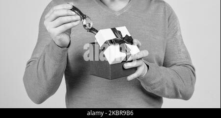 Armbanduhr in Geschenk-Box in der Hand des kurzbeschnittenen Mannes, Herrentag Stockfoto