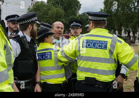 Polizeibeamte verhaften einen pro-kurdischen und anti-Erdogan-Demonstranten in der Nähe des Parlaments, nachdem er vor dem Auto mit dem britischen Premierminister Boris Johnson lief, der nach der Fragestunde der Premierministerin in die Downing Street abfuhr, Das Fahrzeug muss anhalten und anschließend am 17. Juni 2020 in London, England, von hinten vom nächsten Fahrzeug im Konvoi getroffen werden. (Foto von Wiktor Szymanowicz/NurPhoto) Stockfoto