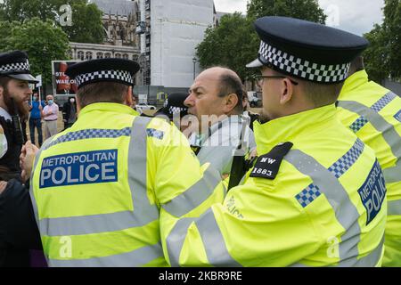 Polizeibeamte verhaften einen pro-kurdischen und anti-Erdogan-Demonstranten in der Nähe des Parlaments, nachdem er vor dem Auto mit dem britischen Premierminister Boris Johnson lief, der nach der Fragestunde der Premierministerin in die Downing Street abfuhr, Das Fahrzeug muss anhalten und anschließend am 17. Juni 2020 in London, England, von hinten vom nächsten Fahrzeug im Konvoi getroffen werden. (Foto von Wiktor Szymanowicz/NurPhoto) Stockfoto