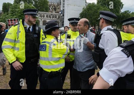 Polizeibeamte verhaften einen pro-kurdischen und anti-Erdogan-Demonstranten in der Nähe des Parlaments, nachdem er vor dem Auto mit dem britischen Premierminister Boris Johnson lief, der nach der Fragestunde der Premierministerin in die Downing Street abfuhr, Das Fahrzeug muss anhalten und anschließend am 17. Juni 2020 in London, England, von hinten vom nächsten Fahrzeug im Konvoi getroffen werden. (Foto von Wiktor Szymanowicz/NurPhoto) Stockfoto