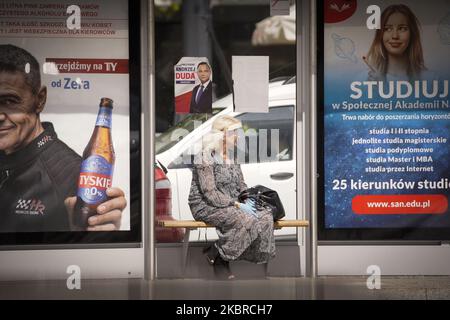 Am 19. Juni 2020 in Warschau, Polen, ist eine Frau zu sehen, die eine Plastikabdeckung auf dem Gesicht hält, die unter einem Plakat für den Präsidentschaftskandidaten Andrzej Duda steht. Am 28. Juni werden die Polen in der ersten Runde der Präsidentschaftswahlen abstimmen. Die Wahlen waren ursprünglich für den 30. Mai geplant, wurden aber aufgrund der Coronavirus-Epidemie annulliert. (Foto von Jaap Arriens/NurPhoto) Stockfoto