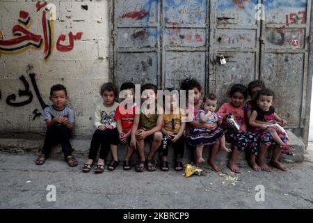 Ein Mädchen trägt am 20. Juni ein kleines Kind in der Nähe ihrer Wohnung im al-Shati-Lager für palästinensische Flüchtlinge im zentralen Gazastreifen. 2020. Der Weltflüchtlingstag wird jedes Jahr am 20. Juni begangen, um das Leid der Zehnmillionen Menschen hervorzuheben, die aufgrund von Krieg oder Verfolgung gezwungen wurden, aus ihren Häusern zu fliehen. Fast ein Drittel der registrierten palästinensischen Flüchtlinge, mehr als 1,5 Millionen Menschen, leben in 58 anerkannten palästinensischen Flüchtlingslagern in Jordanien, dem Libanon, der Arabischen Republik Syrien, dem Gazastreifen und dem Westjordanland, einschließlich Ost-Jerusalem. (Foto von Majdi Fathi/NurPhoto) Stockfoto