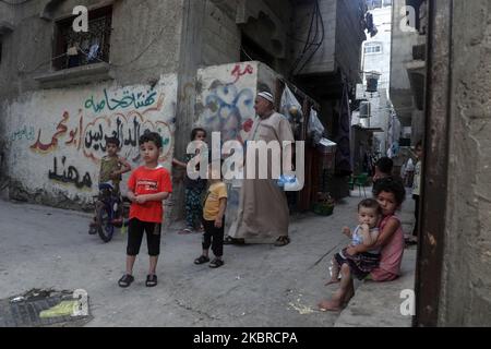 Ein Mädchen trägt am 20. Juni ein kleines Kind in der Nähe ihrer Wohnung im al-Shati-Lager für palästinensische Flüchtlinge im zentralen Gazastreifen. 2020. Der Weltflüchtlingstag wird jedes Jahr am 20. Juni begangen, um das Leid der Zehnmillionen Menschen hervorzuheben, die aufgrund von Krieg oder Verfolgung gezwungen wurden, aus ihren Häusern zu fliehen. Fast ein Drittel der registrierten palästinensischen Flüchtlinge, mehr als 1,5 Millionen Menschen, leben in 58 anerkannten palästinensischen Flüchtlingslagern in Jordanien, dem Libanon, der Arabischen Republik Syrien, dem Gazastreifen und dem Westjordanland, einschließlich Ost-Jerusalem. (Foto von Majdi Fathi/NurPhoto) Stockfoto