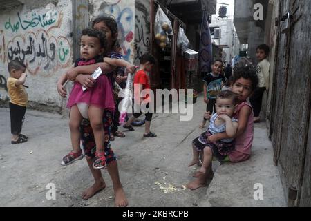 Ein Mädchen trägt am 20. Juni ein kleines Kind in der Nähe ihrer Wohnung im al-Shati-Lager für palästinensische Flüchtlinge im zentralen Gazastreifen. 2020. Der Weltflüchtlingstag wird jedes Jahr am 20. Juni begangen, um das Leid der Zehnmillionen Menschen hervorzuheben, die aufgrund von Krieg oder Verfolgung gezwungen wurden, aus ihren Häusern zu fliehen. Fast ein Drittel der registrierten palästinensischen Flüchtlinge, mehr als 1,5 Millionen Menschen, leben in 58 anerkannten palästinensischen Flüchtlingslagern in Jordanien, dem Libanon, der Arabischen Republik Syrien, dem Gazastreifen und dem Westjordanland, einschließlich Ost-Jerusalem. (Foto von Majdi Fathi/NurPhoto) Stockfoto