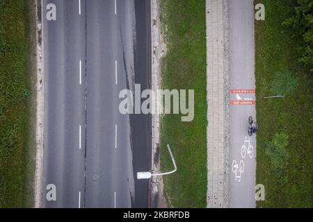 Ein Radfahrer kommt einem Schild auf dem Radweg entgegen, auf dem er davor warnt, am 21. Juni 2020 in Warschau, Polen, Wildenten zu überqueren. Die Verwaltung der Stadtstraßen von Warschau (ZDM) hat Schilder auf Fahrradwegen gemalt, um Radfahrer vor dem Überqueren von Merganser, Wirld Enten zu warnen. Zwischen März und Mai machen wilde Enten die gefährliche Überquerung gegenüber der geschäftigen Czerniakowski Straße von ihrem Teich zur Weichsel. (Foto von Jaap Arriens/NurPhoto) Stockfoto