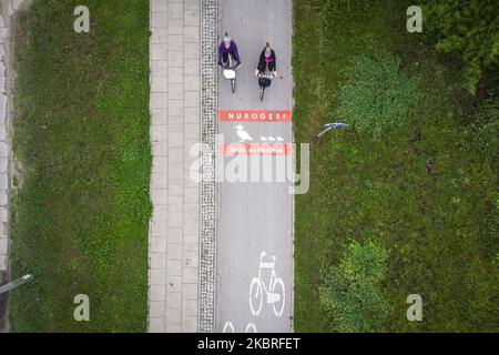 Ein Radfahrer kommt einem Schild auf dem Radweg entgegen, auf dem er davor warnt, am 21. Juni 2020 in Warschau, Polen, Wildenten zu überqueren. Die Verwaltung der Stadtstraßen von Warschau (ZDM) hat Schilder auf Fahrradwegen gemalt, um Radfahrer vor dem Überqueren von Merganser, Wirld Enten zu warnen. Zwischen März und Mai machen wilde Enten die gefährliche Überquerung gegenüber der geschäftigen Czerniakowski Straße von ihrem Teich zur Weichsel. (Foto von Jaap Arriens/NurPhoto) Stockfoto