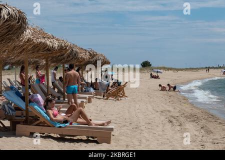 Sandstrand an einem sonnigen Tag und Beach Bar in Nea Irakleia, Chalkidiki in Griechenland mit den ersten Strandbesuchern, die zum Schwimmen und Sonnenbaden kommen. Chalkidiki ist berühmt für den goldenen Sand, das kristallklare, transparente Wasser und den einfachen Zugang zu den Stränden. Strandbars, Hotels und organisierte Strände wurden in Griechenland eröffnet, da die Maßnahmen zur Sperrung durch das Coronavirus Covid-19 in Griechenland aufgehoben wurden und die Tourismusbranche seit Juni 15 durch Öffnung der Grenzen und Aufnahme von Touristen wieder in Gang kommen kann. 22. Juni 2020 (Foto von Nicolas Economou/NurPhoto) Stockfoto