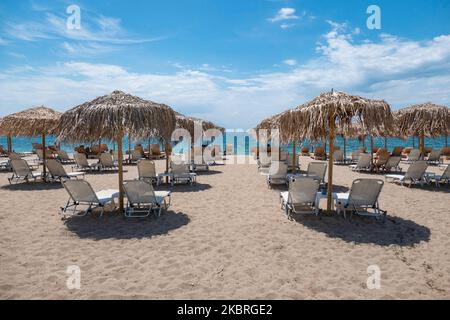 Sandstrand an einem sonnigen Tag und Beach Bar in Nea Irakleia, Chalkidiki in Griechenland mit den ersten Strandbesuchern, die zum Schwimmen und Sonnenbaden kommen. Chalkidiki ist berühmt für den goldenen Sand, das kristallklare, transparente Wasser und den einfachen Zugang zu den Stränden. Strandbars, Hotels und organisierte Strände wurden in Griechenland eröffnet, da die Maßnahmen zur Sperrung durch das Coronavirus Covid-19 in Griechenland aufgehoben wurden und die Tourismusbranche seit Juni 15 durch Öffnung der Grenzen und Aufnahme von Touristen wieder in Gang kommen kann. 22. Juni 2020 (Foto von Nicolas Economou/NurPhoto) Stockfoto