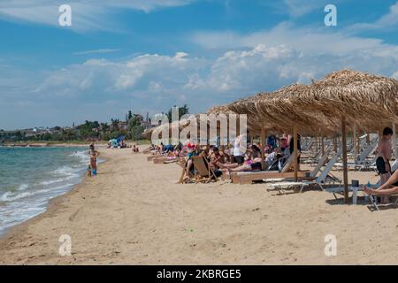 Sandstrand an einem sonnigen Tag und Beach Bar in Nea Irakleia, Chalkidiki in Griechenland mit den ersten Strandbesuchern, die zum Schwimmen und Sonnenbaden kommen. Chalkidiki ist berühmt für den goldenen Sand, das kristallklare, transparente Wasser und den einfachen Zugang zu den Stränden. Strandbars, Hotels und organisierte Strände wurden in Griechenland eröffnet, da die Maßnahmen zur Sperrung durch das Coronavirus Covid-19 in Griechenland aufgehoben wurden und die Tourismusbranche seit Juni 15 durch Öffnung der Grenzen und Aufnahme von Touristen wieder in Gang kommen kann. 22. Juni 2020 (Foto von Nicolas Economou/NurPhoto) Stockfoto