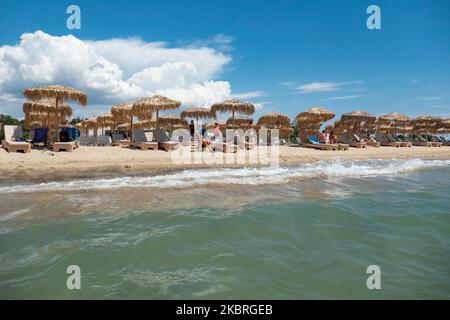 Sandstrand an einem sonnigen Tag und Beach Bar in Nea Irakleia, Chalkidiki in Griechenland mit den ersten Strandbesuchern, die zum Schwimmen und Sonnenbaden kommen. Chalkidiki ist berühmt für den goldenen Sand, das kristallklare, transparente Wasser und den einfachen Zugang zu den Stränden. Strandbars, Hotels und organisierte Strände wurden in Griechenland eröffnet, da die Maßnahmen zur Sperrung durch das Coronavirus Covid-19 in Griechenland aufgehoben wurden und die Tourismusbranche seit Juni 15 durch Öffnung der Grenzen und Aufnahme von Touristen wieder in Gang kommen kann. 22. Juni 2020 (Foto von Nicolas Economou/NurPhoto) Stockfoto