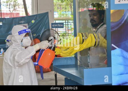 Gesundheitsfachkraft sprüht Desinfektionsmittel, nachdem ein Labortechniker am 23. Juni 2020 in Dhaka, Bangladesch, eine Nasenabstrichprobe von einem Bewohner des Mugda Medical College and Hospital gesammelt hat, während der Ausbruch des Coronavirus weiter anhält (Foto: Mamunur Rashid/NurPhoto) Stockfoto