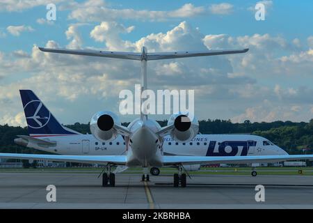 Das Flugzeug VON LOT Polish Airlines passiert in der Nähe eines geparkten Flugzeugs der Gulfstream G550, das auf Andrzej Duda, den derzeitigen polnischen Präsidenten und Kandidaten für die Präsidentschaftswahl 2020, in Krakau-Balice wartet, bevor er ins Weiße Haus fährt, wo er den US-Präsidenten Donald Trump treffen sollte. Am 23. Juni 2020 im Militärflughafen Balice, Krakau, Woiwodschaft Kleinpolen, Polen. (Foto von Artur Widak/NurPhoto) Stockfoto