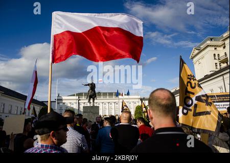 Polnische Nationalisten halten am 23. Juni 2020 in Warschau, Polen, während eines Protestes gegen die GERECHTE Tat Flaggen und Banners in der Hand. Mit Präsident Andrzej Duda, der diese Woche Donald Trump besuchen wird, versammelten sich rechte Aktivisten und Abgeordnete vor dem Präsidentenpalast, um nicht dem zu gehorchen, was angeblich in „NUR“ (oder „447“) handeln soll. Der 2017 vom US-Kongress verabschiedete „Justice for Uncompensated Survivors Today Act“ enthält angeblich Bestimmungen zur Rückgabe von Eigentum, selbst wenn die Eigentümer starben, ohne Nachkommen zu hinterlassen. Rechte Aktivisten, zusammen mit ihrer Vertretung Konfederacja Stockfoto